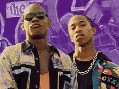 The poster shows two guys posing in front of the purple background.